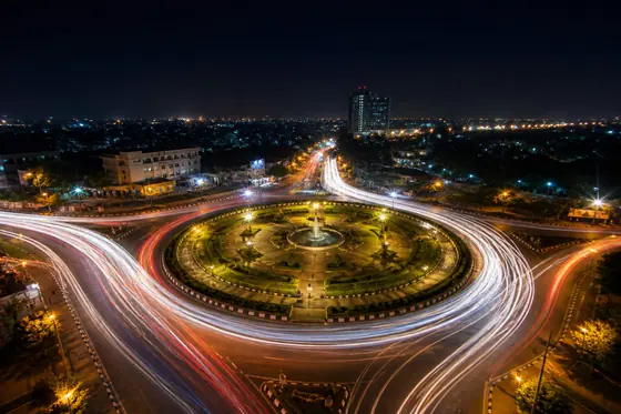 Long Exposure — Traffic light trails at a busy roundabout at night., kết quả ChatGPT.